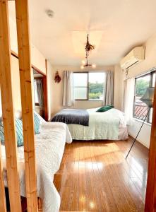 2 camas en una habitación con 2 ventanas en 民泊宿 i s e s h i m a 伊勢内宮前203, en Ise