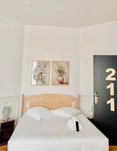 a bedroom with a bed with a phone on it at Hôtel de la paix in Limoges