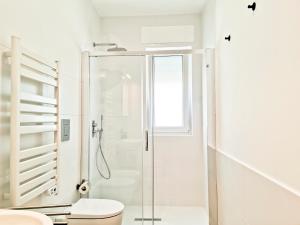 a white bathroom with a shower and a toilet at Blu Blu Apartment in Bari