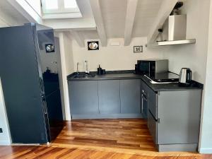 a kitchen with blue cabinets and a counter top at Vanessa's Art Rooftop Attic - City View - San Fedele, Historic Center Como in Como