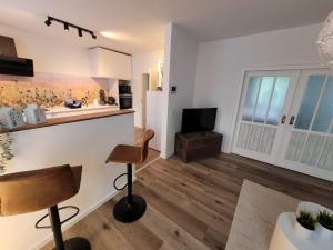 a kitchen and living room with a counter and a television at Ferienwohnung WineTime in Saarburg