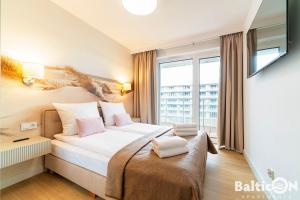 a hotel room with a bed and a window at Apartamenty BalticON Polanki Aqua in Kołobrzeg