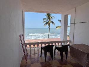 a balcony with two chairs looking out at the ocean at Kapila Beach Resort in Dapoli