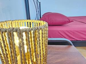 a yellow chair next to a bed with a red pillow at Skyros BnB Calliope in Molos in Skiros