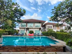 a house with a swimming pool in front of it at Maryo Resort Chiangrai - SHA Plus in Chiang Rai