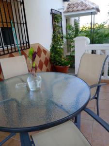 a glass table with chairs and a vase on it at Cortijo Rural Buenavista Montefrio in Montefrío