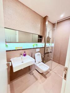 a bathroom with a sink and a toilet and a mirror at Lucentia Residences BBCC LaLaport in Kuala Lumpur