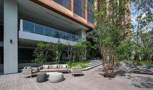 a building with couches and chairs in front of it at Lucentia Residences BBCC LaLaport in Kuala Lumpur