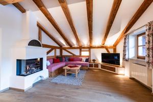 a living room with a fireplace and a tv at Hotel garni Fischerweber am See in Rottach-Egern