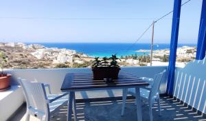 a table and chairs on a balcony with the ocean at Evilion Donoussa Studios in Donoussa