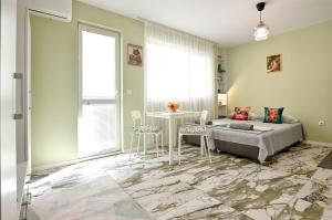 a bedroom with a bed and a table and chairs at Mint Funny Condo in Varna City