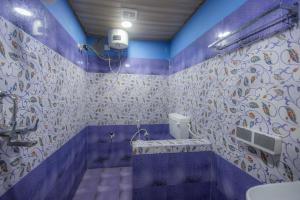 a purple bathroom with a toilet and a sink at Deepiksha Beach Resort Talpona in Magdāl +31 photos
