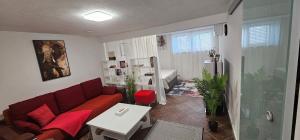 a living room with a red couch and a bathroom at Apartments Sea Pearls in Supetar