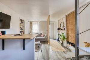 a kitchen and living room with a table and a couch at Maison de ville cosy Disney in Chessy