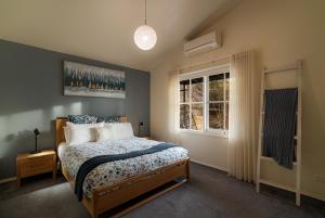 ein Schlafzimmer mit einem Bett und einem Fenster in der Unterkunft BlueMill Cottage in Bright