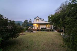 ein kleines weißes Haus mit Garten in der Unterkunft BlueMill Cottage in Bright