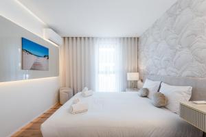 a white bedroom with a large bed with white pillows at GuestReady - A charming place in a private condo in Apúlia