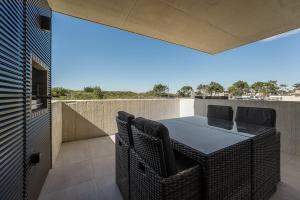 a patio with a table and chairs on a balcony at GuestReady - A charming place in a private condo in Apúlia
