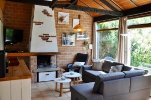 un salon avec un canapé et une cheminée dans l'établissement Boerenslag 48, à Sint Maartensvlotbrug