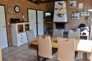 une cuisine et une salle à manger avec une table et des chaises en bois dans l'établissement Boerenslag 48, à Sint Maartensvlotbrug 2 autres photos