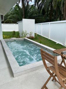 a swimming pool with a table and a chair at Passara Villas in Ban Khlong Son