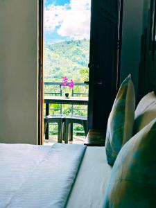 a bedroom with a bed with a view of a balcony at AV Suites in Puerto Galera