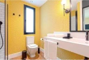 a bathroom with a white toilet and a sink at Central Rooms Cascais, Estoril in Parede