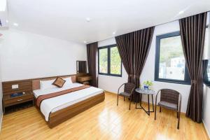 a bedroom with a bed and a table and some windows at Ngọc Bích Luxury in Cat Ba +124 photos
