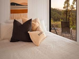 a bedroom with a bed with pillows and a balcony at Aurora Lookout by Tiny Away in Macksville