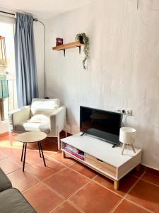 a living room with a couch and a tv at La Casa Vertical casco histórico de Segorbe in Segorbe