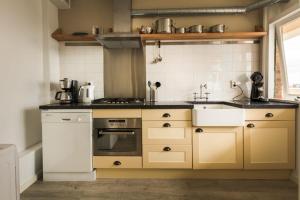 una cocina con estufa y fregadero en Strand166, en Egmond aan Zee