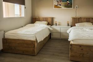 Un dormitorio con dos camas individuales y una ventana. en Strand166, en Egmond aan Zee