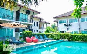 a pool in front of a building with chairs and an umbrella at Maryo Resort Chiangrai - SHA Plus in Chiang Rai