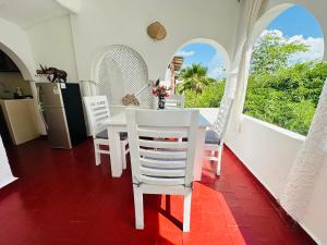 a kitchen and dining room with a table and chairs at Studio Cecile in Malindi
