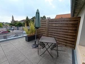 una mesa y una sombrilla en el balcón en Studios les 3 Eclats, en Saint-Laurent-sur-Sèvre