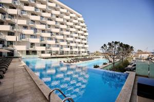 a swimming pool in front of a building at Ricky Apartment in Infinity Spa & Pool in Mamaia Sat/Năvodari
