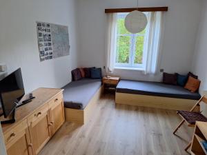 a room with two beds and a tv and a window at Ubytování U Trůdy in Smržovka