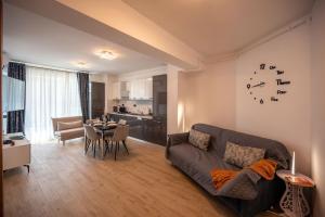 a living room with a couch and a dining room at Ricky Apartment in Infinity Spa & Pool in Mamaia Sat/Năvodari