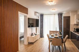 a kitchen and dining room with a table and chairs at Ricky Apartment in Infinity Spa & Pool in Mamaia Sat/Năvodari