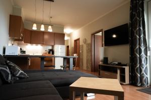 a living room with a couch and a kitchen at BALA Resort Apartman in Siófok