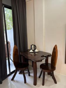 a wooden table and two chairs and a table and a window at Casa de Apolinar Resort in Carrascal