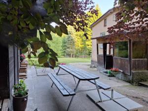 a picnic table and benches outside of a building at Ubytování U Trůdy in Smržovka