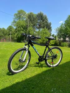 a bike parked on the grass in a field at Śpimy u Dziadków - APARTAMENTY BIESZCZADY in Nowosielce Kozickie