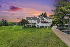 a large white house with people sitting on the porch at Beautiful Comfy 2 Bedroom Condo Stunning Golf Course Views 5166 in Traverse City