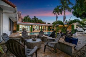 a patio with chairs and a table and a pool at Private neighborhood Heated Pool Lush Surroundings Harbor Key RESlDENCES in Fort Lauderdale