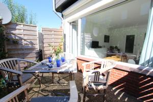 a patio with a table and chairs on a balcony at Beachhouse in Langeoog +10 photos
