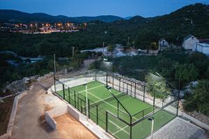 una vista aérea de una pista de tenis con una pista de tenis en Villa Lovorika - Padel, Cageball, Basketball & Heated Pool, en Trnbusi