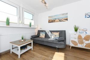 ein Wohnzimmer mit Sofa und Tisch in der Unterkunft Ferienwohnung Haus Boje "Knurrhahn" in Neuharlingersiel