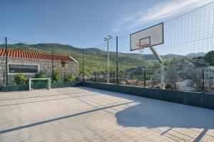 una cancha de baloncesto al aire libre con un aro de baloncesto en Villa Lovorika - Padel, Cageball, Basketball & Heated Pool, en Trnbusi 60 fotos más