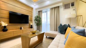 a living room with a couch and a tv at Cozy & Modern 2BR Unit in Manhattan Cubao with Balcony in Sampong